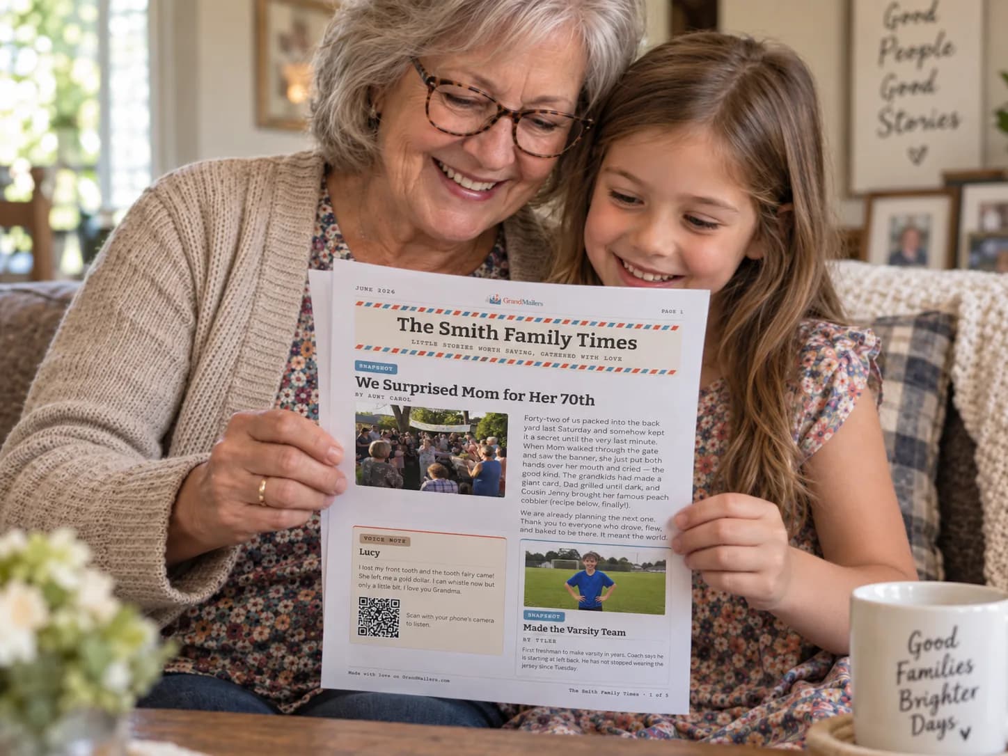 A grandmother and her granddaughter on the sofa together, reading this month’s printed GrandMailers family newsletter between them
