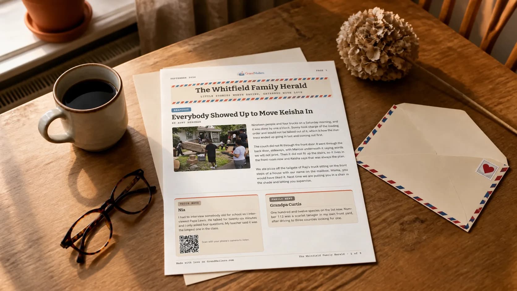 This month’s printed GrandMailers family newsletter open on a kitchen table beside the airmail envelope it arrived in, a cup of coffee and a pair of reading glasses